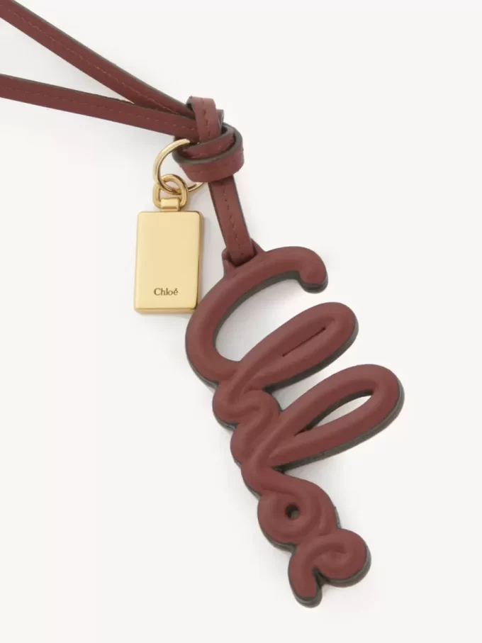 Bijou de sac logo en cuir brillant Bijou de sac logo en cuir brillant
